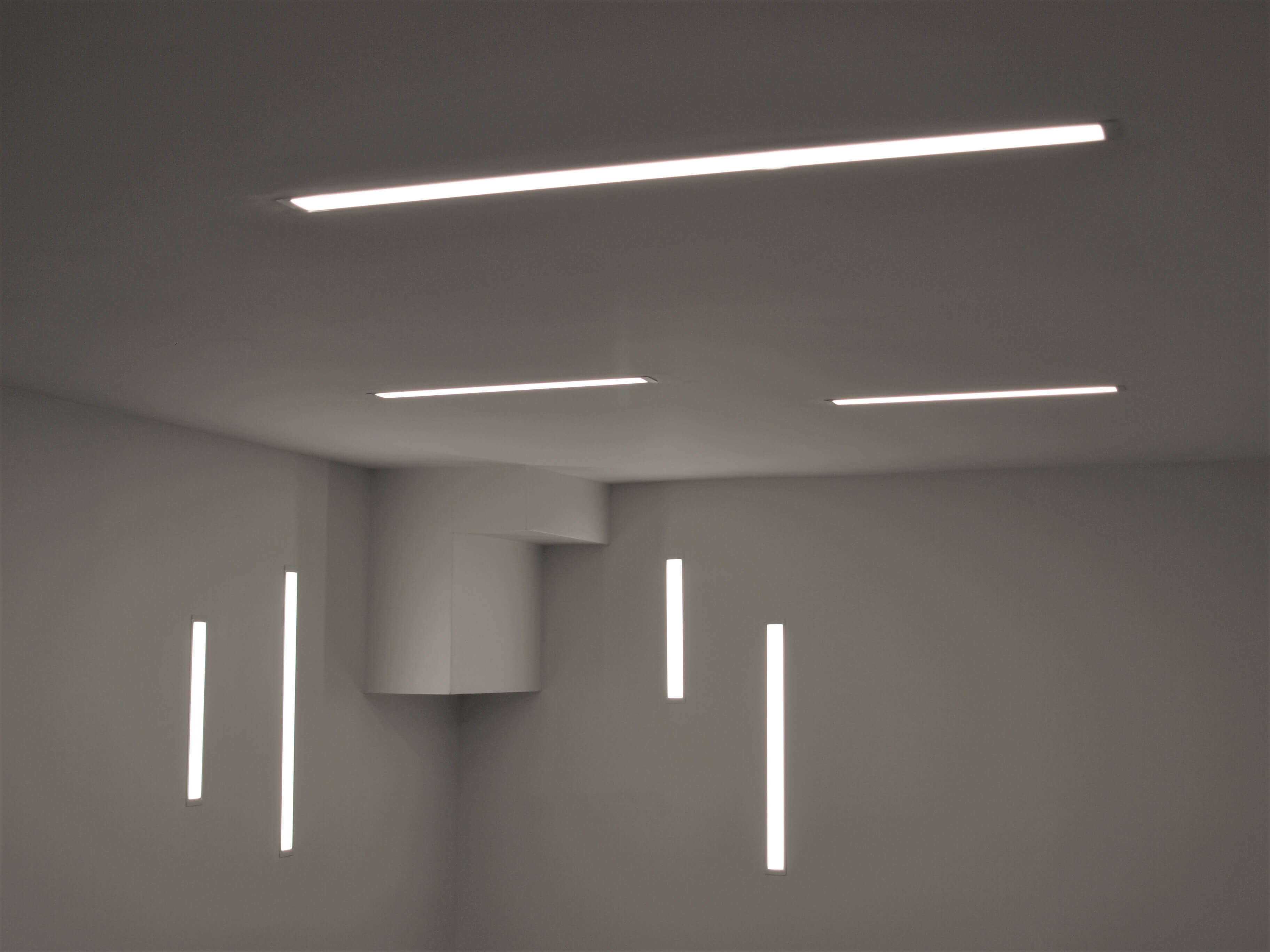 Wall-recessed and ceiling-recessed linear LED lighting in a renovated basement office