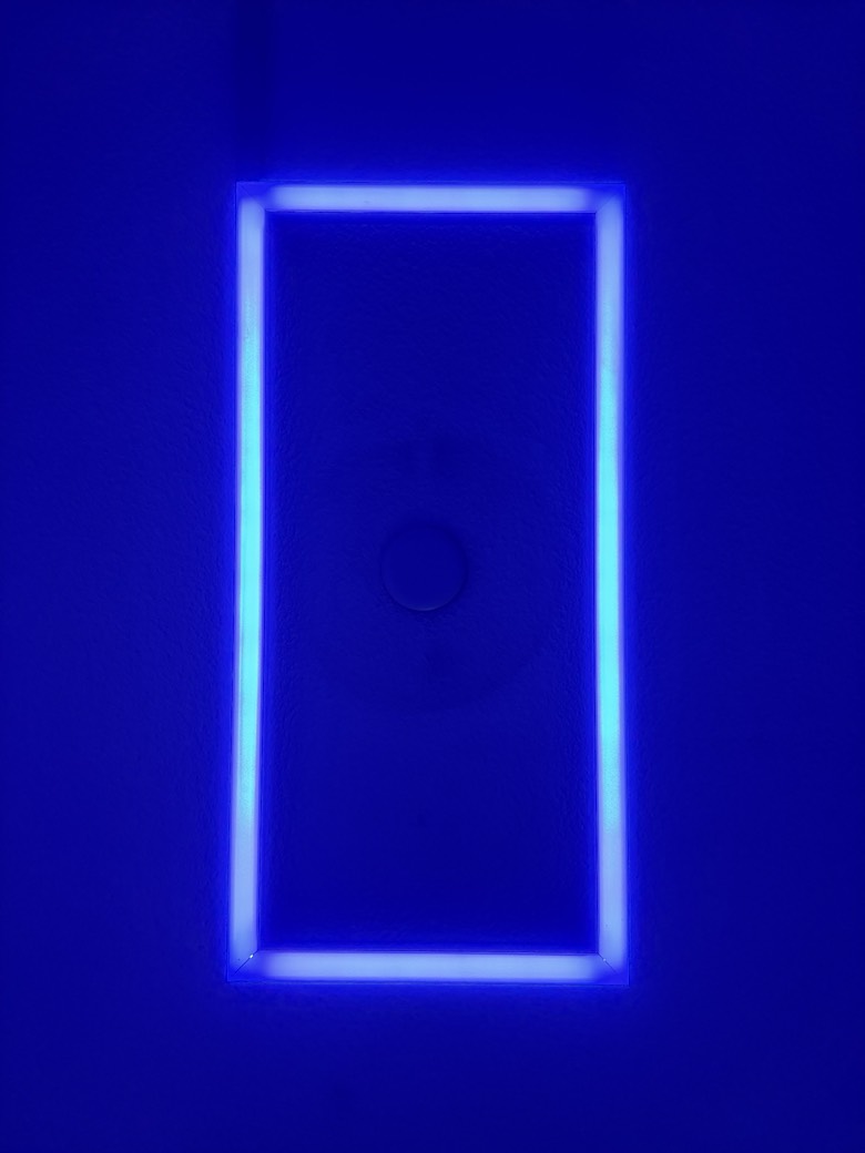 Close detail of the rectangular LED fixture glowing blue